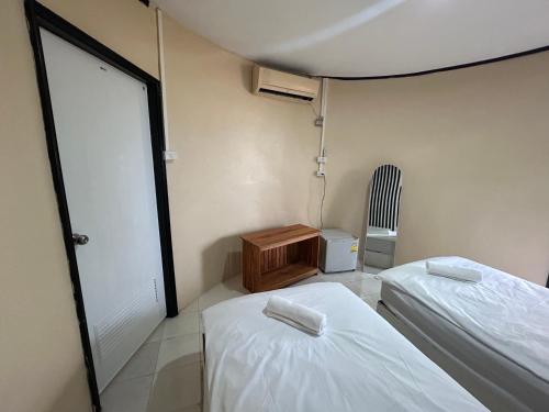 帕干岛Soukaina Beach Bungalow的小房间设有两张床和椅子