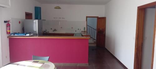 姆布尔L'essentiel nianing的厨房配有粉色的柜台和桌子