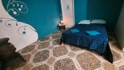 里奥加耶戈斯Moni Moni hab的一间卧室设有一张床和蓝色的墙壁