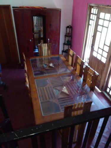 努沃勒埃利耶Green View In Nuwaraeliya的一间设有一张木桌的房间,周围摆放着椅子