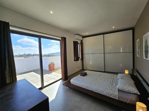 MġarrMalta Unique Penthouse Spacious Terrace-Sleeps 8的一间卧室设有一张床和一个大窗户