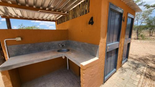OpuwoOpuwo Country Lodge Campsite的大楼一侧带水槽的浴室