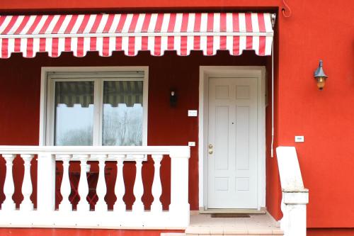CeggiaCasa Delisa的一间红色的房子,有白色的门和窗户