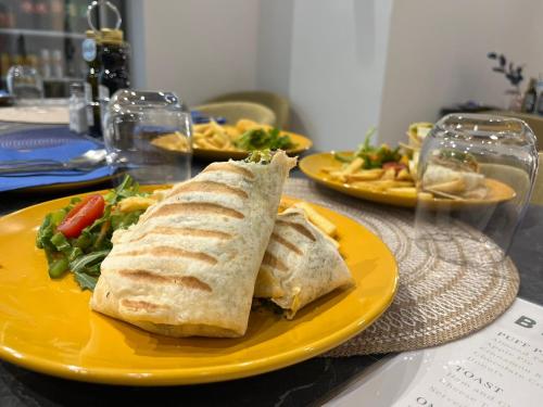 Tal-PietàThe Central guesthouse的桌上的黄色盘子,上面有三明治和沙拉