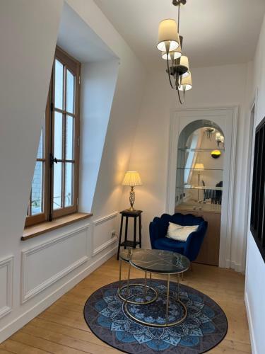 迪纳尔Le Royal XIX Dinard vue mer luxe的客厅配有桌子和蓝椅