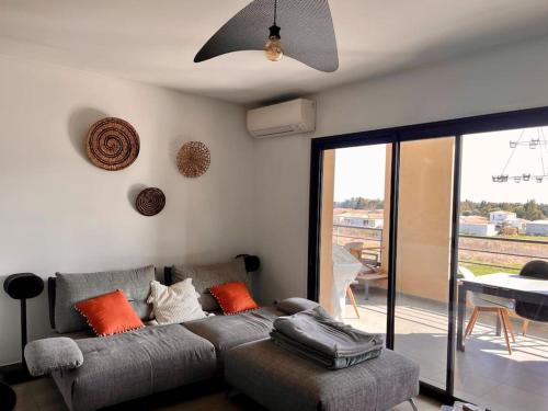 卢恰纳Appartement T3 Lucciana的客厅配有带橙色枕头的灰色沙发