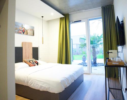 HégenheimArrow Hôtel的一间卧室设有一张床和一个大窗户