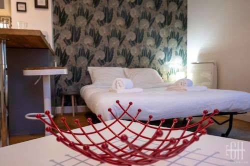图尔Le Fidji / 100m Gare的一间房间,一张床铺和一张桌子上的红色篮子