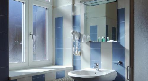 卡尔博宁克罗达罗萨酒店的蓝色和白色的浴室设有水槽和窗户