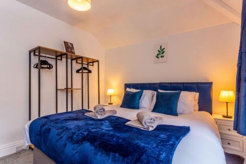 霍特惠斯尔Wonderful House near the Castle的一间卧室配有一张带蓝色毯子的大床