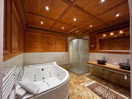 费拉迪普利米罗Hotel El Mondin的大型浴室设有浴缸和淋浴。
