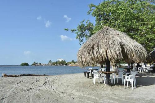 科韦尼亚斯Cabañas covemar的海滩上的桌椅,带草伞
