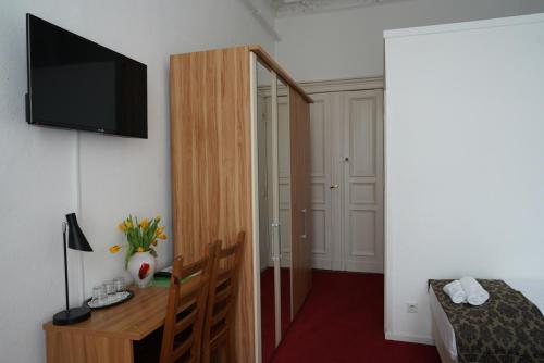 柏林柏林膳食公寓酒店的客房设有一张床、一张书桌和电视
