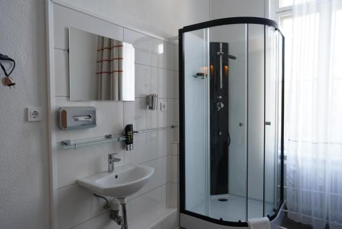 柏林柏林膳食公寓酒店的一间带玻璃淋浴和水槽的浴室