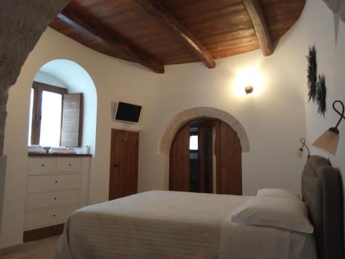 阿尔贝罗贝洛迪比科度假酒店的一间卧室设有一张床和一个拱形门廊