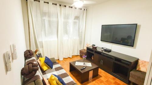 桑托斯Santos Gonzaga - Vista mar & localização perfeita的带沙发和电视的客厅