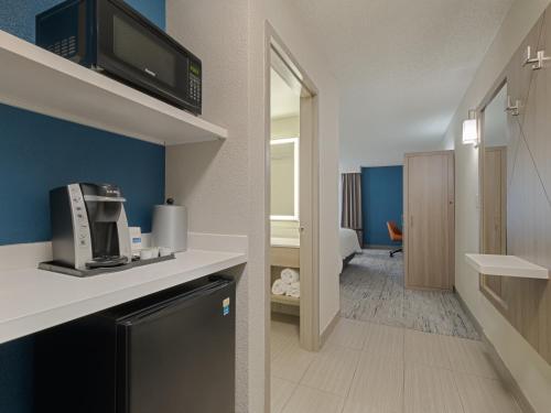 普兰塔寻Holiday Inn Express Hotel & Suites Ft. Lauderdale-Plantation, an IHG Hotel的一间小客房,设有一间配有微波炉的厨房