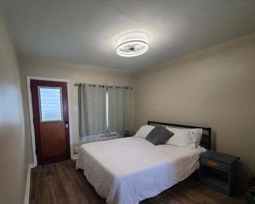 怀尔德伍德Hotel on Magnolia East 'HOME'的卧室配有白色的床和窗户。