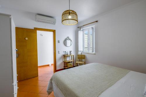 拉戈斯Casa Luma B&B的一间卧室设有一张床、一个窗口和一张桌子