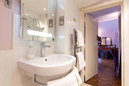 埃耶Frogs Hall B&B的白色的浴室设有水槽和镜子
