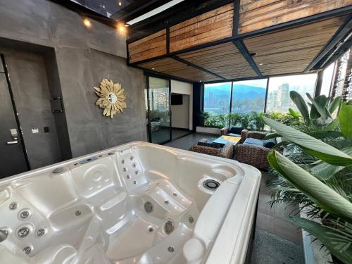 麦德林Hotel 47 Medellin Center的带窗户的客房内的大浴缸