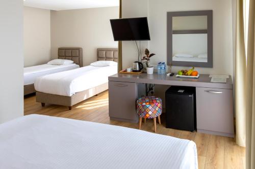 安塔利亚Mene City Hotel的酒店客房配有两张床和一张带镜子的书桌