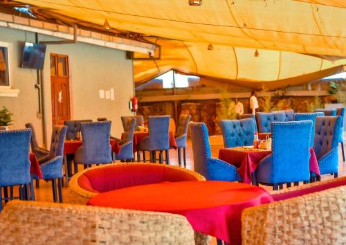 MasenoGalore Luxury Resort的一间设有桌子和蓝色椅子及桌子的餐厅