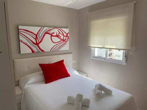 塞维利亚Ritual Sevilla, Fedriani的卧室配有白色的床和红色枕头