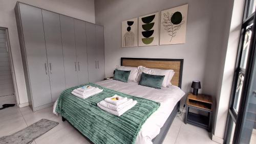 比勒陀利亚Luxurious Upmarket Apartment的一间卧室配有带毛巾的床