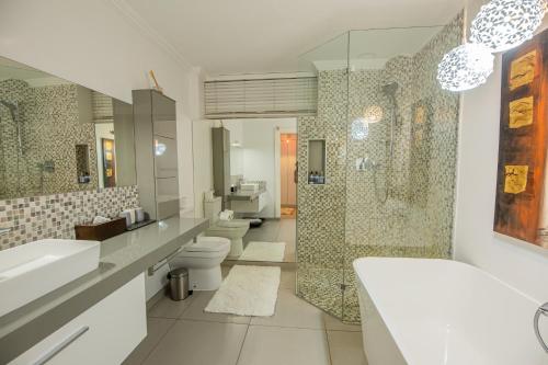 温特和克Belvedere Boutiqe Hotel的一间带两个盥洗盆、淋浴和两个卫生间的浴室