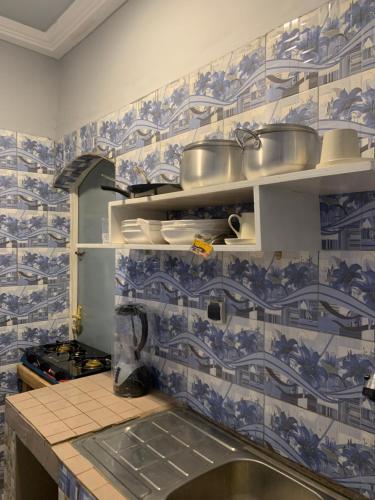 瓦加杜古Villa JFK2的厨房的墙壁上铺有蓝色和白色的瓷砖。