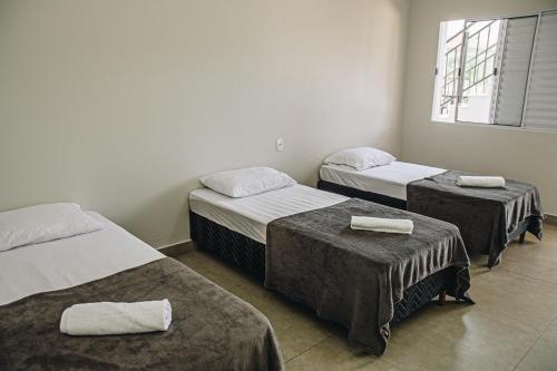 圣若昂-达巴拉Pousada Casa Vista Bela São José da Barra Capitólio的一间设有三张床的客房,备有毛巾