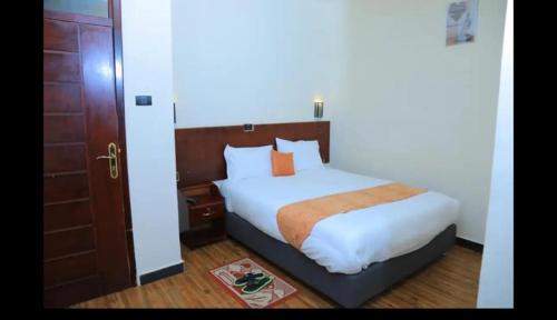 阿克苏姆Obelisk Hotel Axum的一间卧室配有一张床和一扇木门