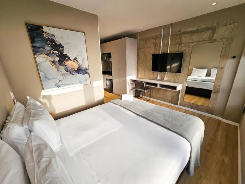 弗洛里亚诺波利斯Bewiki的卧室配有一张白色大床和电视。