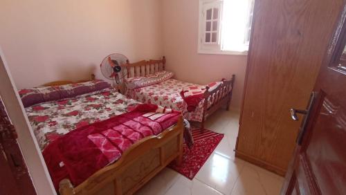 锡瓦Nubian Bayt Ward in Siwa的一间卧室设有两张单人床和一扇门