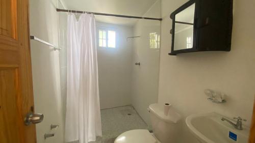 查梅Dharma Casa Holistica, Vivero, Yoga y Retiros的白色的浴室设有卫生间和水槽。