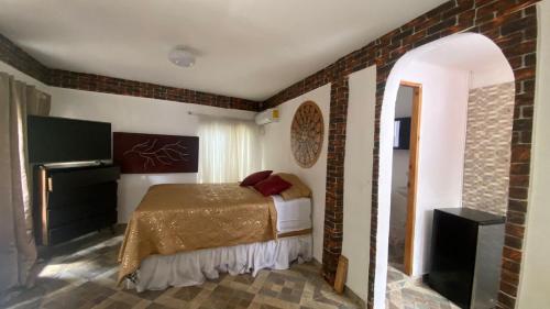 查梅Dharma Casa Holistica, Vivero, Yoga y Retiros的一间卧室设有一张床和砖墙
