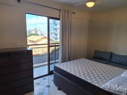 卡波布里奥Locação Temporada Cabo Frio RJ.的一间卧室设有一张床和一个大窗户