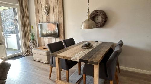 哈嫩克利博克斯维斯ferienapartment hahnenklee Apart 1的一间带木桌和椅子的用餐室
