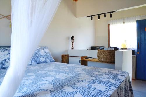 卡拉伊瓦Chalés Cabocla da Lua的一间卧室配有一张带蓝色和白色棉被的床