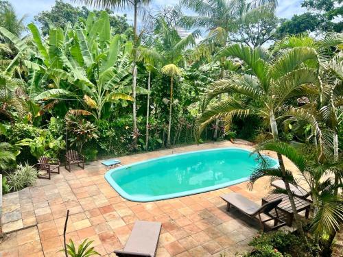 马劳Ayo Bistrô Pousada的棕榈树花园内的游泳池