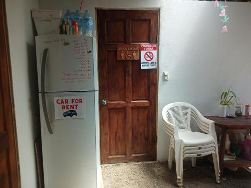 阿拉胡埃拉Hogar tico-estadounidense cerca de aeropuerto的厨房配有冰箱、桌子和椅子