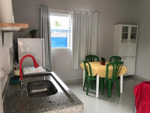 帕尔马斯Residencial Jasmim的厨房配有桌子和绿色椅子