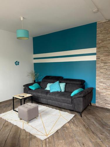 居让梅斯特拉Wilo Gujan的客厅配有黑色沙发和蓝色的墙壁