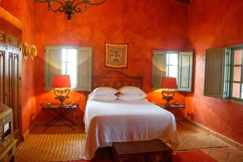 圣米格尔-德阿连德Casa 1 - Beautiful house at San Miguel with pool and views.的一间卧室配有一张带橙色墙壁和窗户的床。