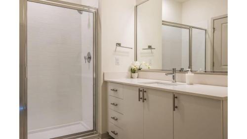 路易斯威尔Stunning Nulu 1BR CozySuites 02的一间带两个水槽和玻璃淋浴间的浴室