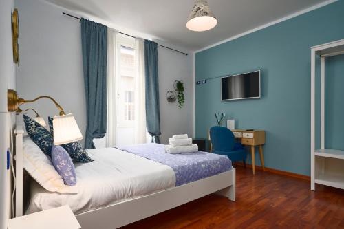斯培西亚Quiet Night Affittacamere La Spezia的一间卧室设有蓝色的墙壁、一张床和一张书桌