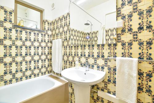 阿尔布费拉Casa dos Avós的浴室设有黄色和蓝色的瓷砖墙壁和水槽