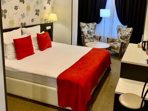 第比利斯East Gate Boutique Hotel的配有红色枕头的床的酒店客房