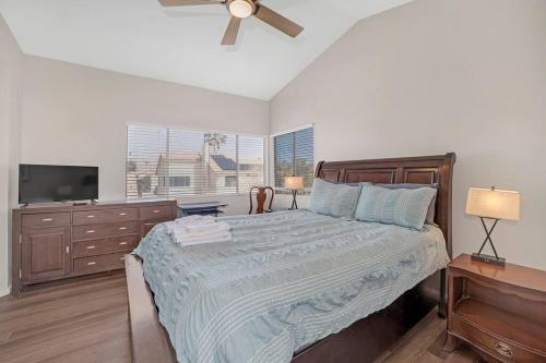 拉斯维加斯Luxury modern home in Las Vegas的一间卧室配有带梳妆台的床和电视。
